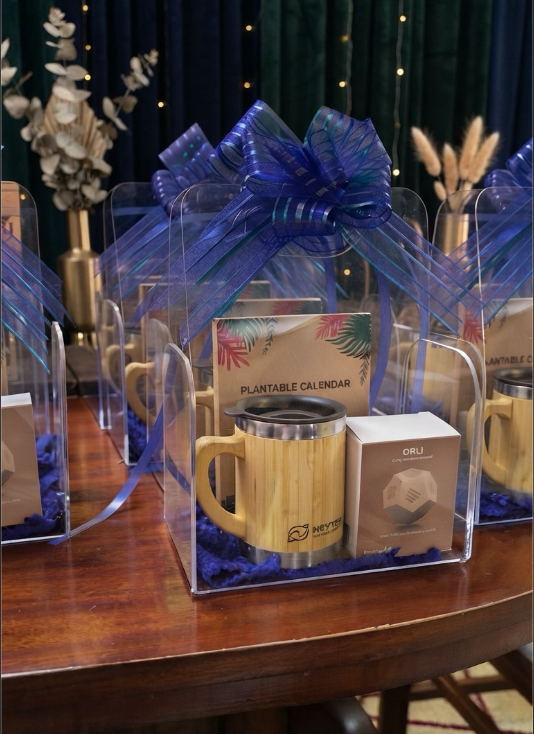 Clear acrylic gift set with bamboo travel mug, motivational cube and plantable calendar, tied with a blue ribbon