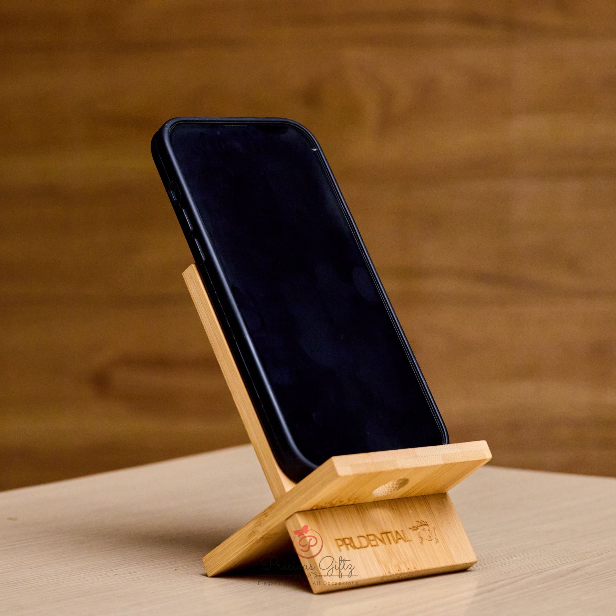 Personalised wooden corporate phone holder engraved with Prudential branding
